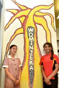Students paint a tree before they leave